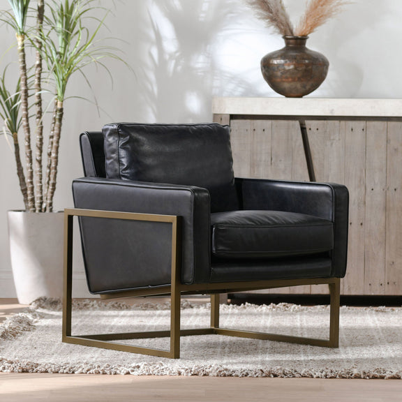 Black leather-look club chair with thick armrests and cushioned seat, gold frame