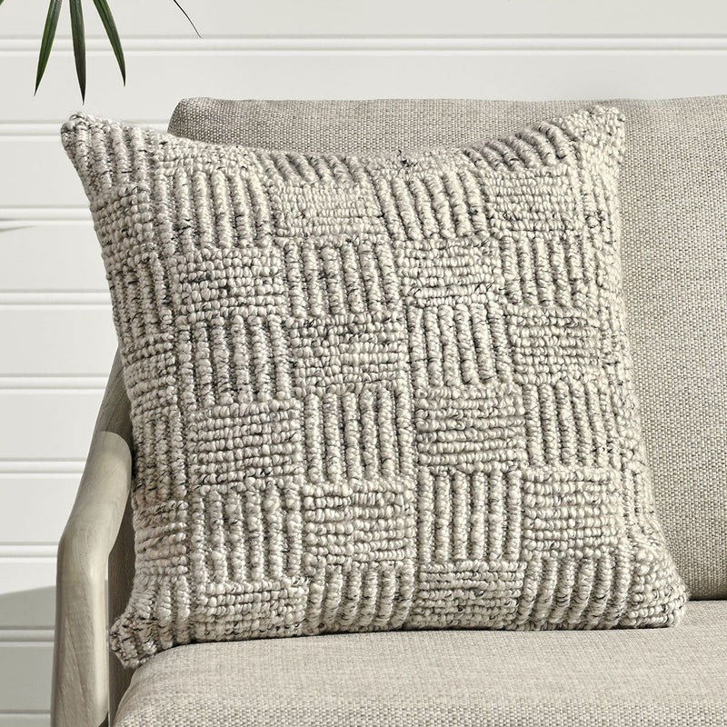 Textured gray Vico pillow with raised vertical grid pattern, placed on upholstered seat