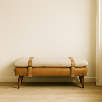 Light brown leather hide bench with padded beige top, stud trim, and wooden legs