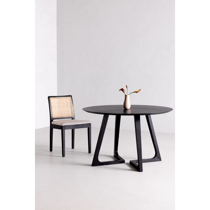Round dining table with dark tabletop and four-sided pedestal base with X cutouts