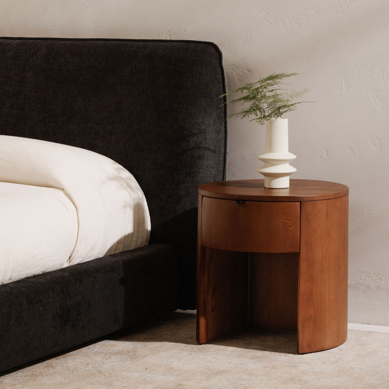 Brown one-drawer nightstand with round top and single drawer front
