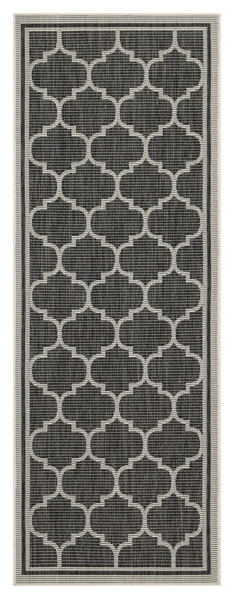 Dark charcoal polypropylene area rug with repeating quatrefoil pattern and thin border