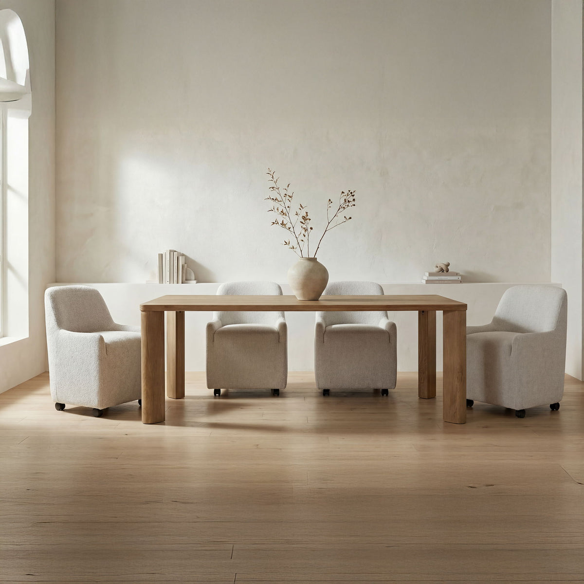 Large wooden dining table with wide legs and upholstered armchairs