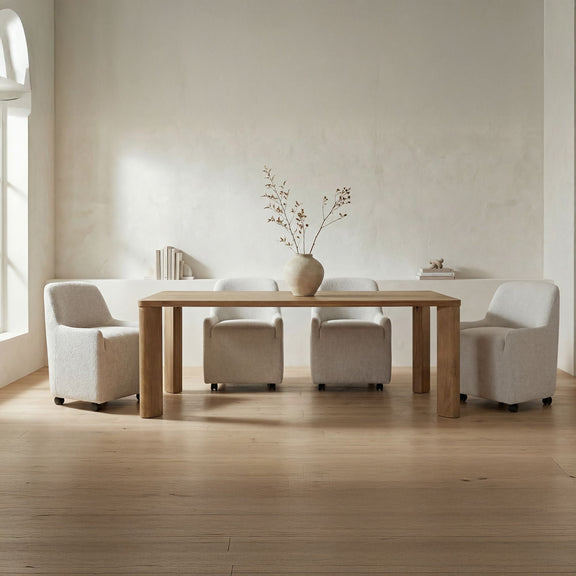 Large wooden dining table with wide legs and upholstered armchairs