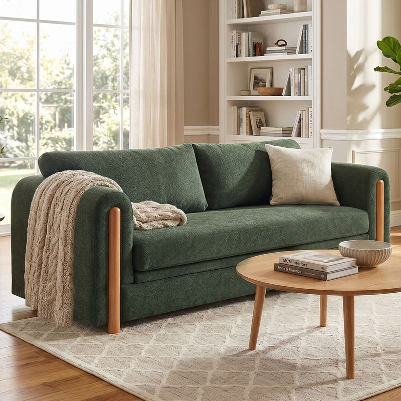 Dark green 3-seat upholstered couch with wooden legs and beige throw pillow