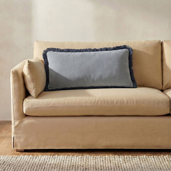 Lumbar cushion with light blue center panel and navy fuzzy edge trim