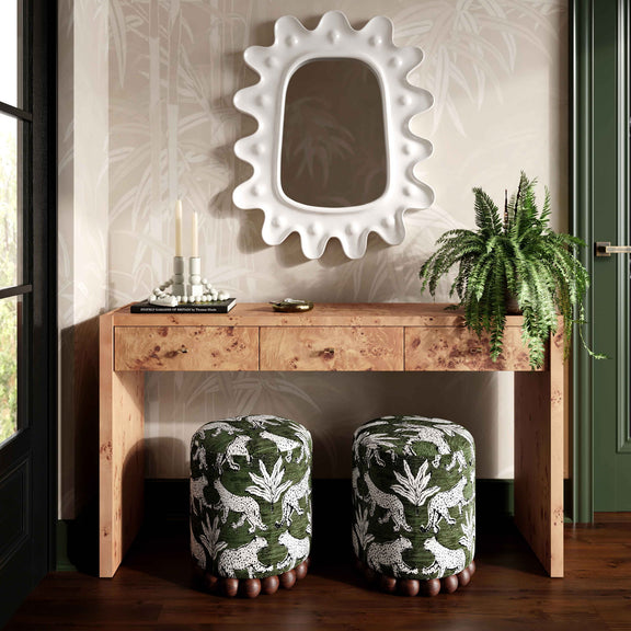 Set of two dark green animal-print ottomans with dark wood ball bases.