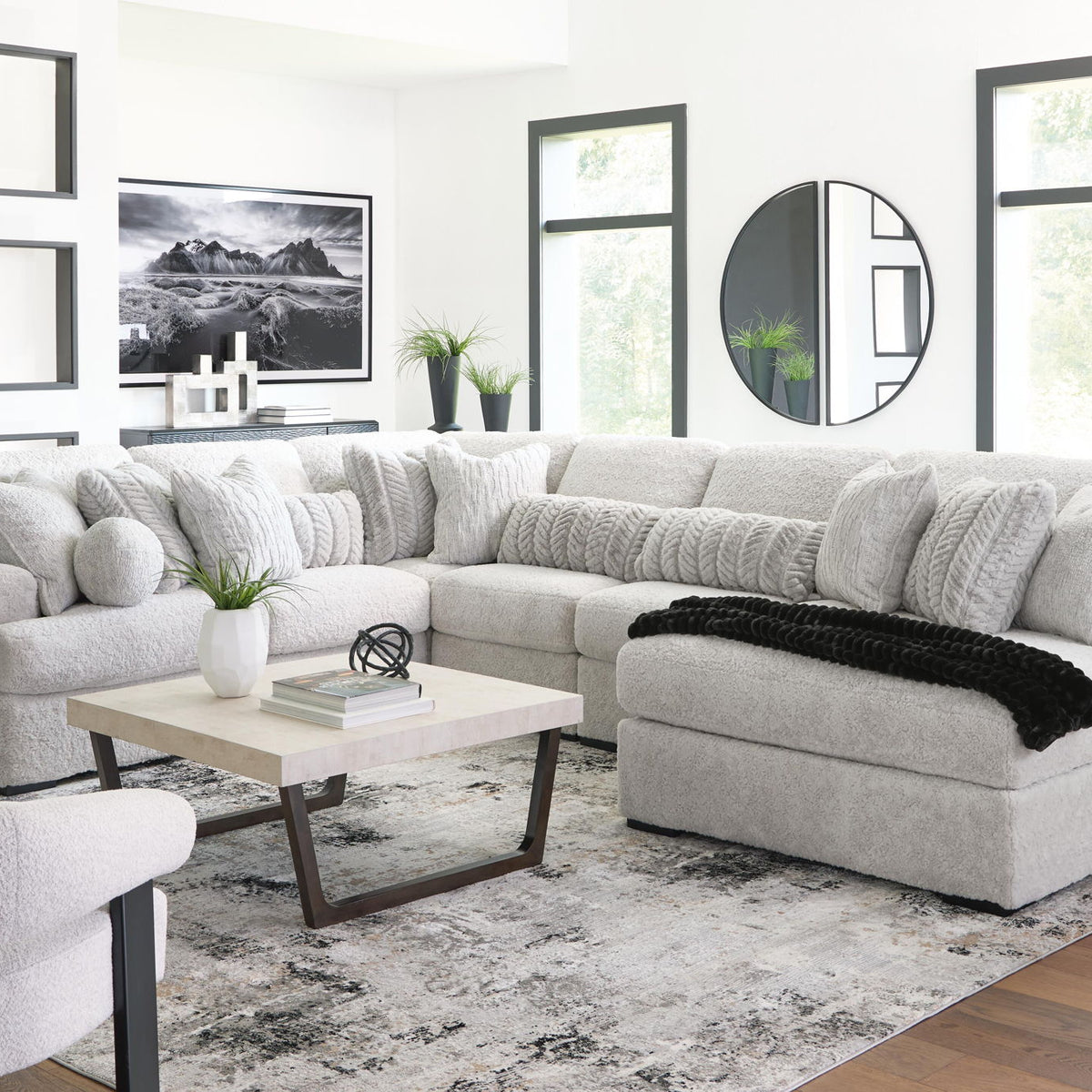 White sectional sofa with chaise, padded ottoman seat, and textured cushion back