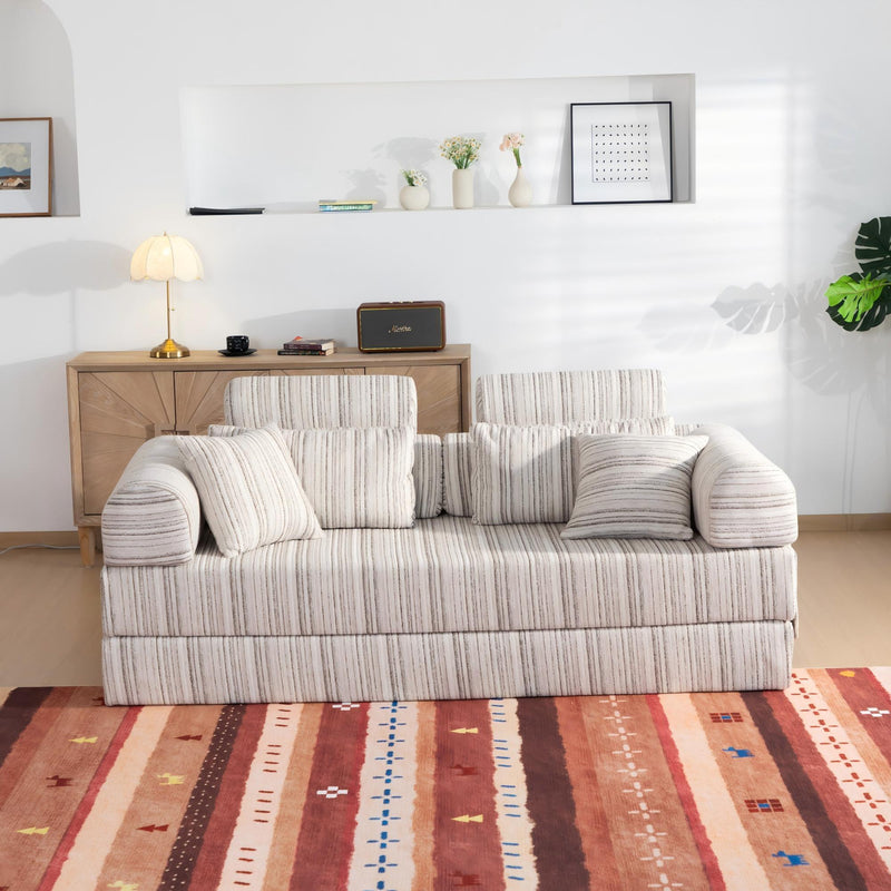 Gray striped sleeper sofa bed in living room, rolled arms with 3 back pillows