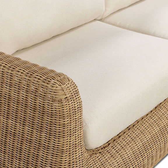 Close-up of outdoor sofa armrest and white cushion with woven wicker texture