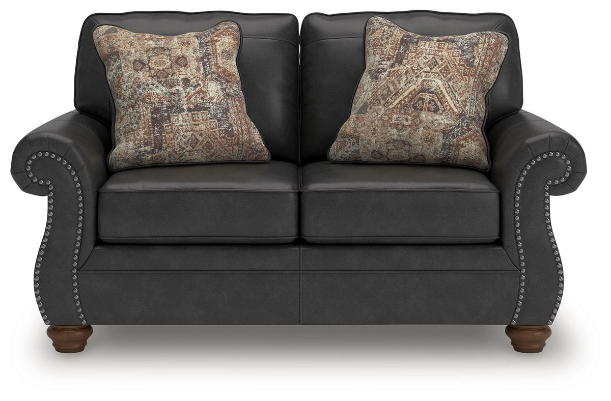 Dark gray sofa with rounded arm details and two patterned accent pillows