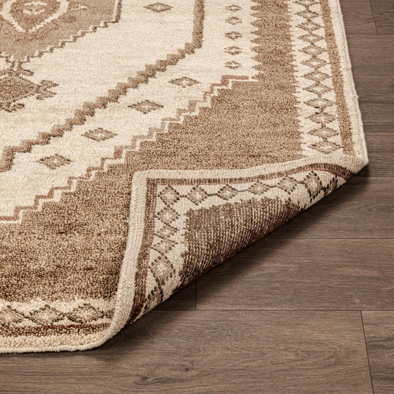 Corner of Luxor hand-knotted rug in cream and desert brown, detailed trim and texture