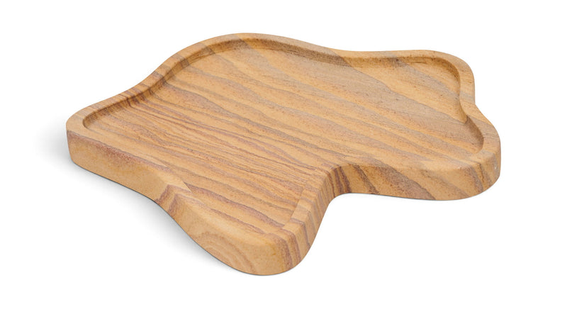 Light brown marble tray with wavy grain lines and rounded leaf shape.