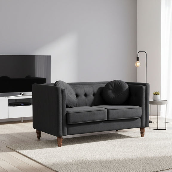 Black fabric two-seater loveseat with tufted back and rounded bolster pillow