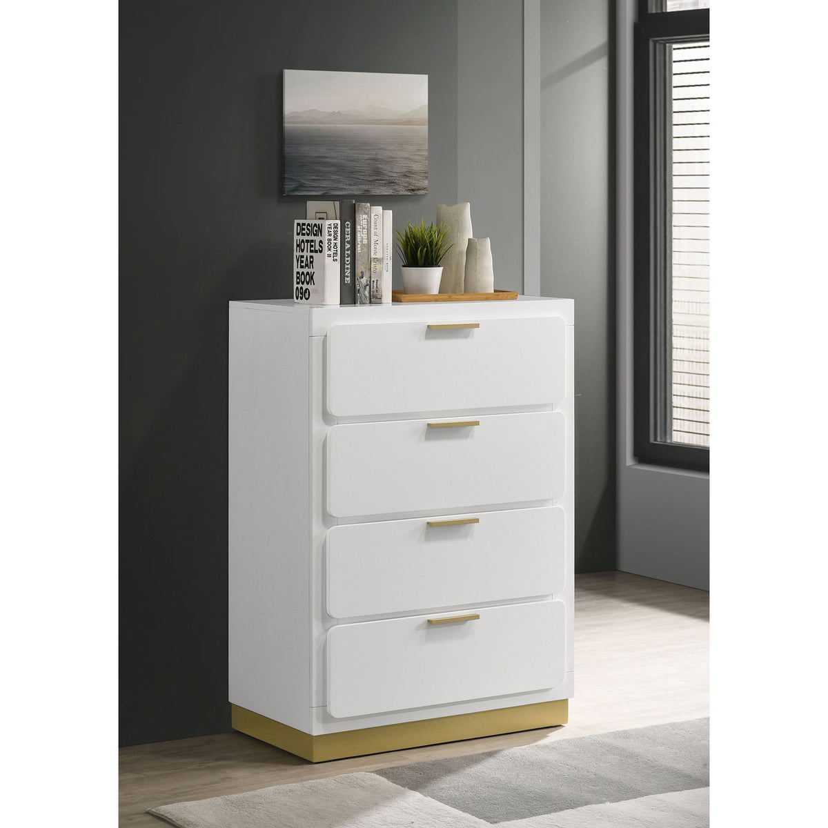 White four-drawer chest with gold bar handles and recessed drawer fronts