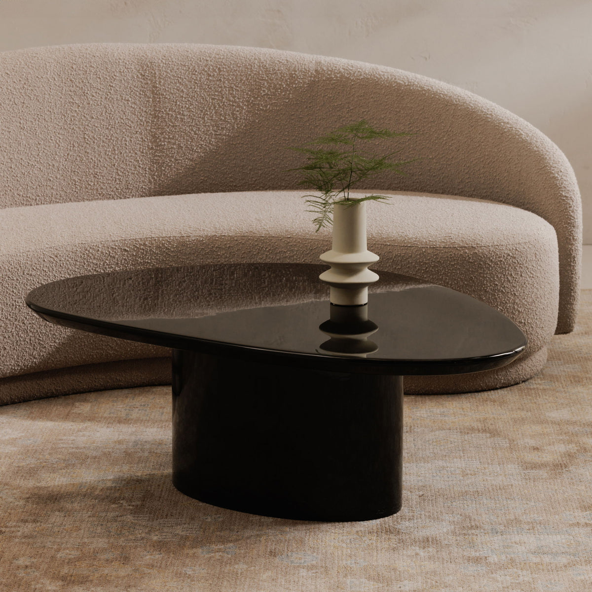 Round black lacquer coffee table with pedestal base and reflective tabletop