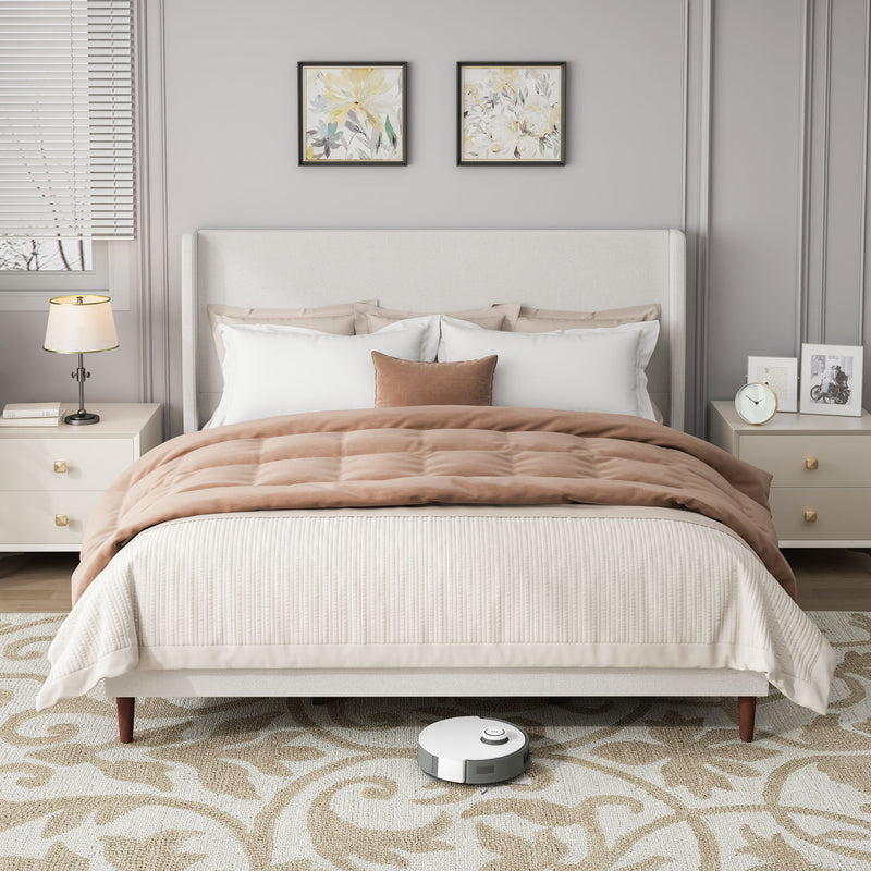 Upholstered bed with tall white headboard, white bedding, and brown quilt