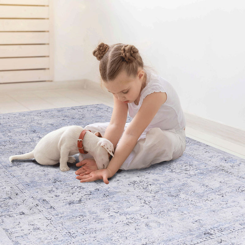 Blue and cream washable runner rug with abstract pattern, toddler and dog on it