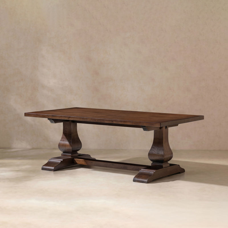 Dark brown rectangular coffee table with turned pedestal legs and lower shelf