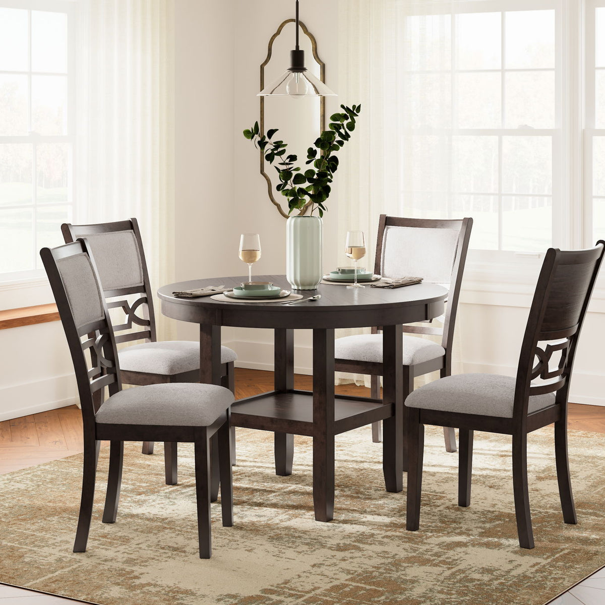 Brown round dining table set with four gray-upholstered chairs