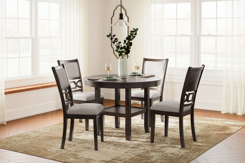 Brown round dining table set with four gray-upholstered chairs
