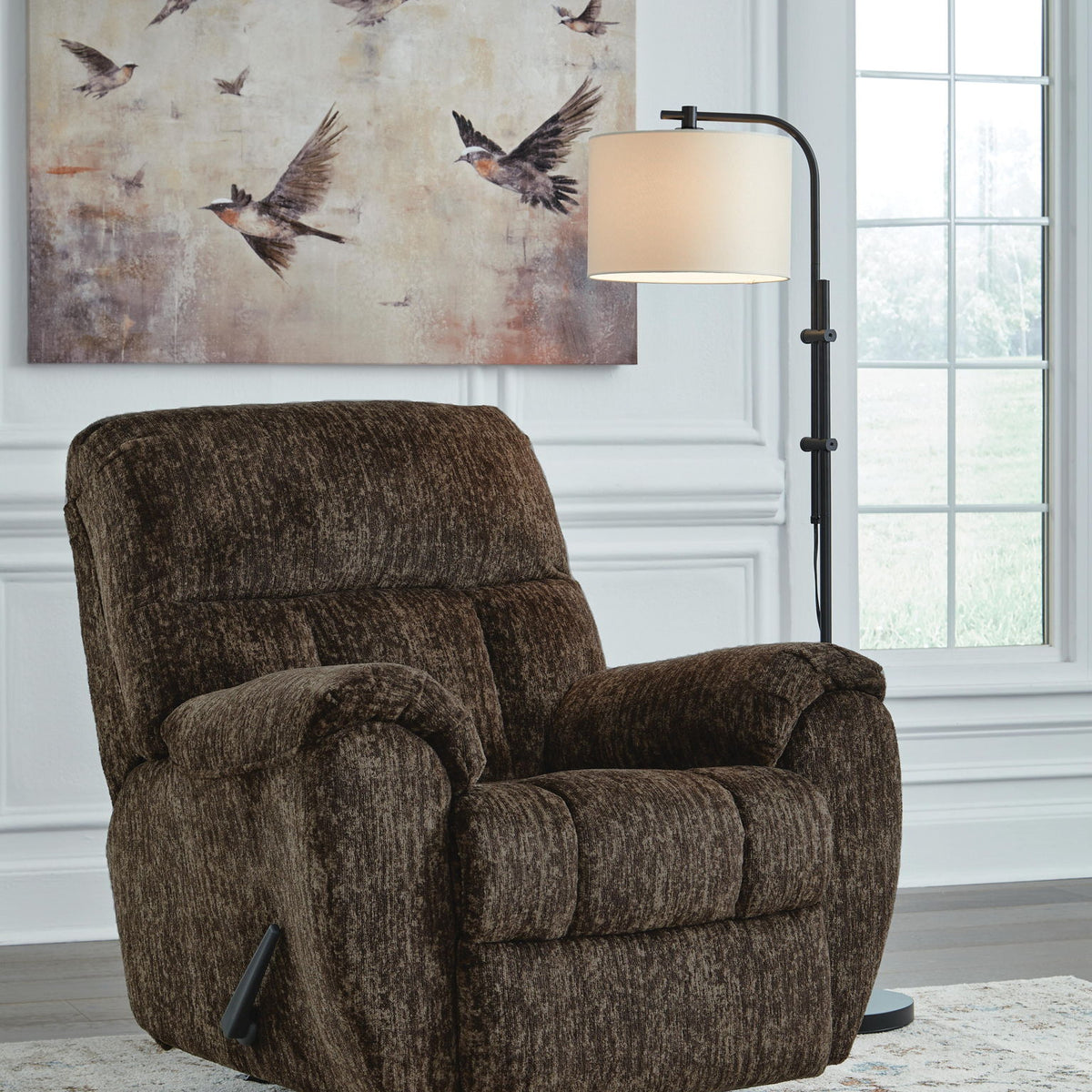 Brown fabric rocker recliner chair with rounded arms and cushioned recline back