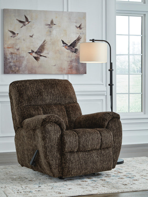 Brown fabric rocker recliner chair with rounded arms and cushioned recline back