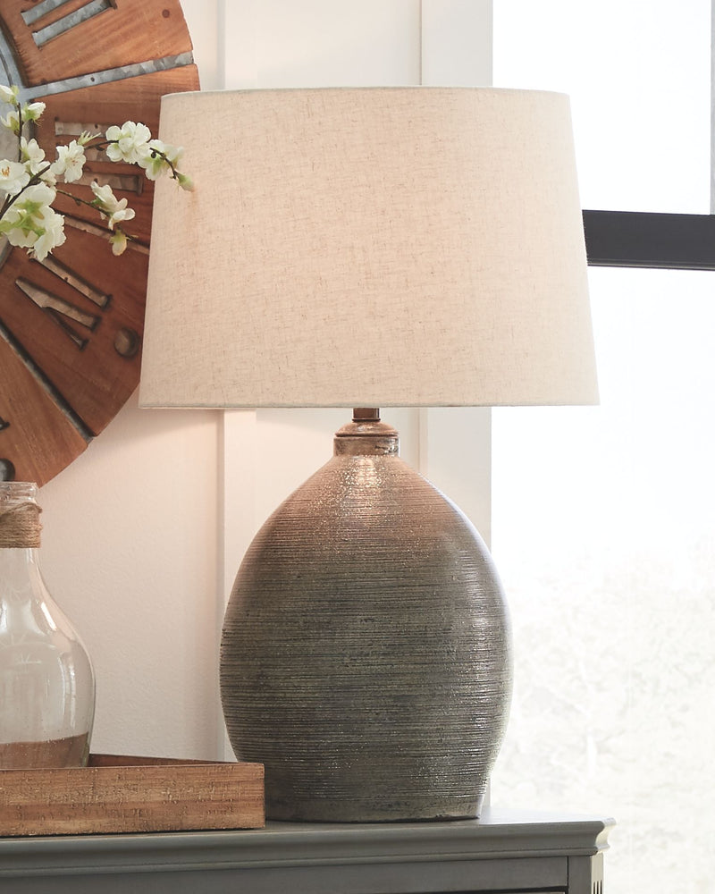 Gray textured ceramic table lamp with beige drum shade on console