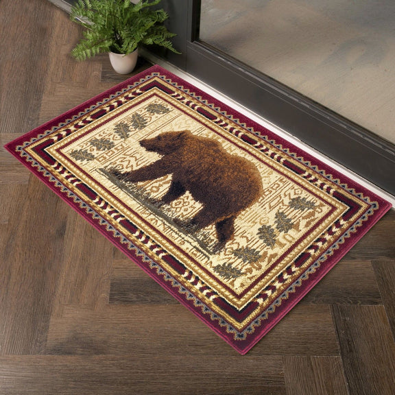 Lodge area rug with beige field, dark bear silhouette, and red border