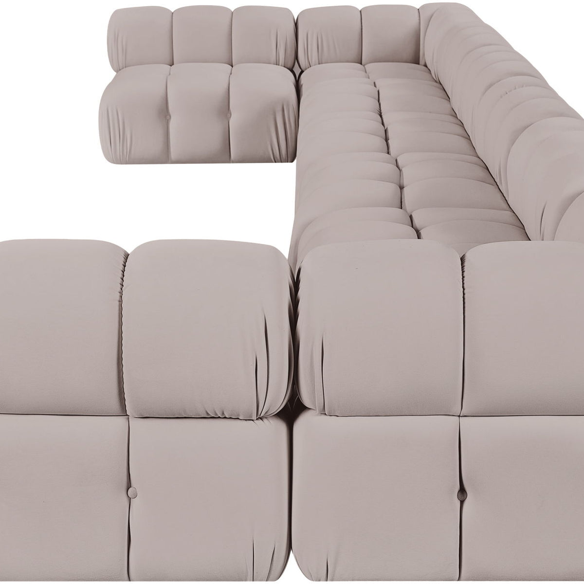 Light beige modular sectional sofa with tufted cushions and curved chaise corner