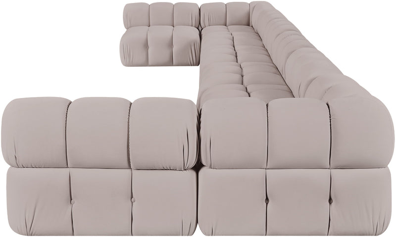 Light beige modular sectional sofa with tufted cushions and curved chaise corner