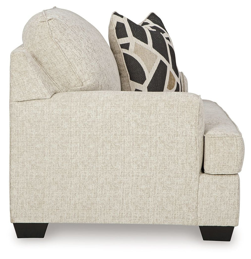 Light gray chair and a half sofa with textured upholstery and geometric pillow