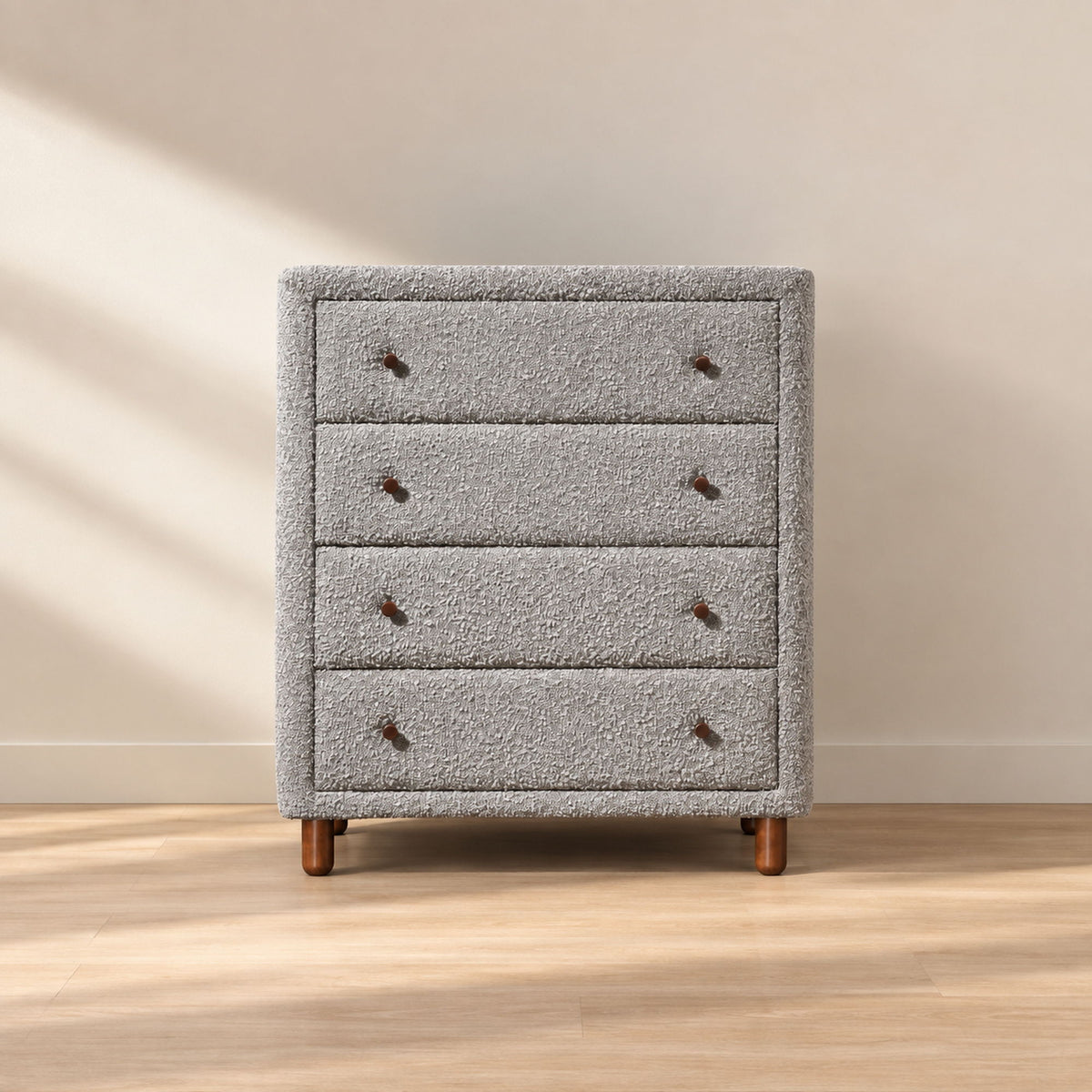Gray upholstered chest with four drawers, nailhead details, and tapered legs