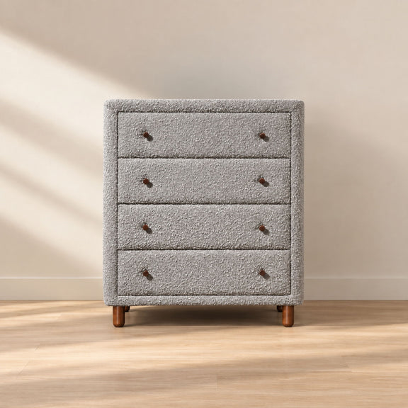 Gray upholstered chest with four drawers, nailhead details, and tapered legs