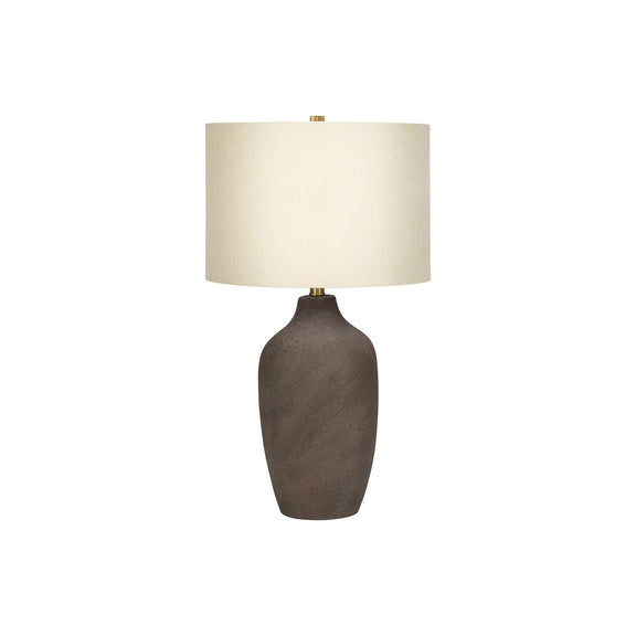 Dark gray ceramic table lamp with off-white fabric drum shade and brass base stem
