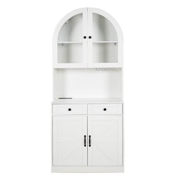 White arched pantry cabinet with glass-front upper shelves, open counter, two drawers and lower doors