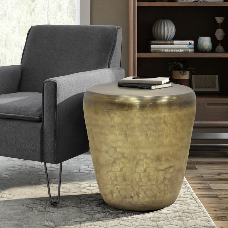 Handcrafted metal side table in gold, hammered drum shape with rounded top and tapered base.