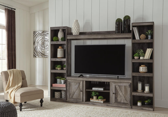Gray entertainment center with TV, shelving, and central fireplace-style opening
