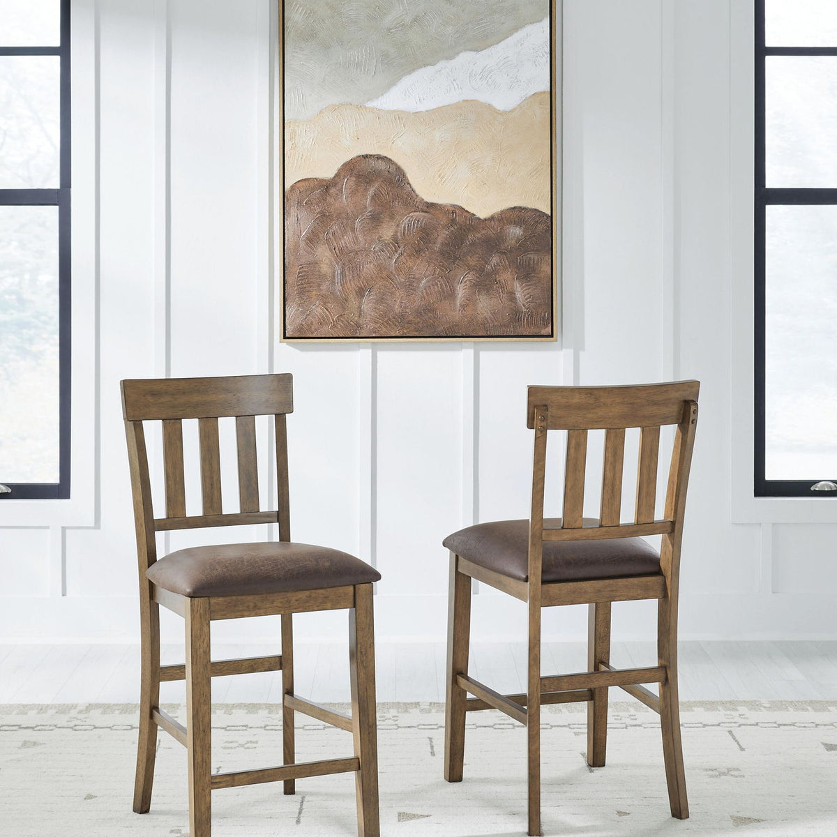 Set of 2 light brown barstools with dark upholstered seats and slatted backs.