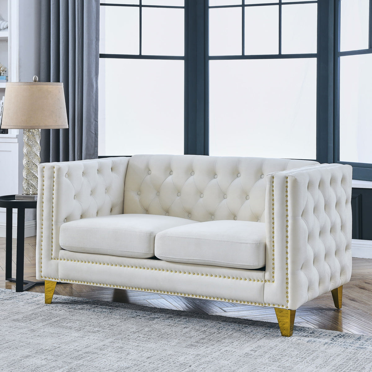 White button-tufted upholstered loveseat with studded trim and gold-toned feet