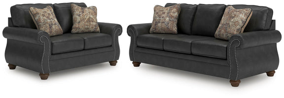 Living room set with dark gray loveseat and sofa, nailhead trim, patterned accent pillows
