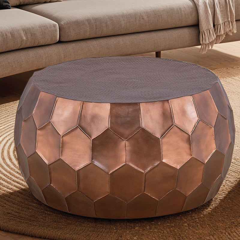 Round coffee table with bronze hex-pattern metal sides and gray fabric top