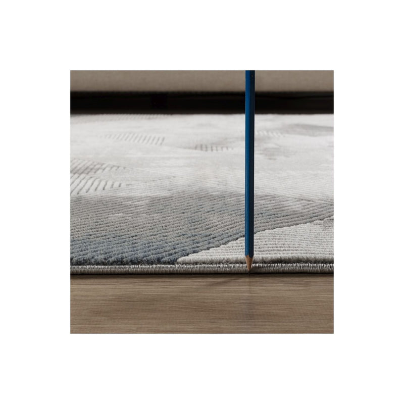 Gray geometric rug edge detail with textured pile and stitched border