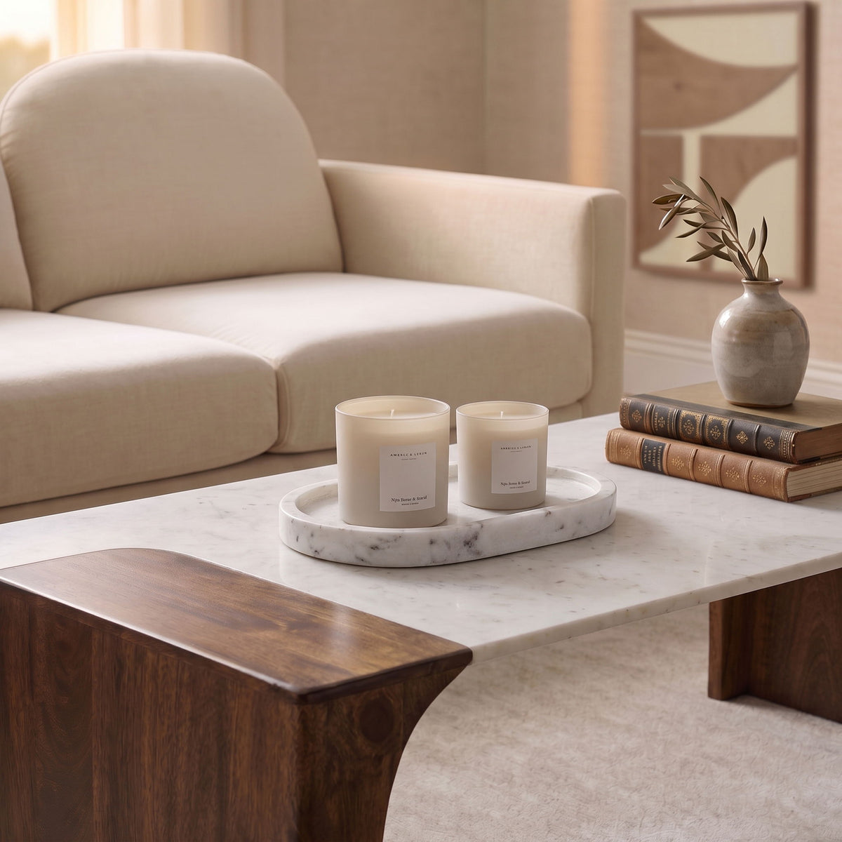 Round marble tray holding two white candles on a table.