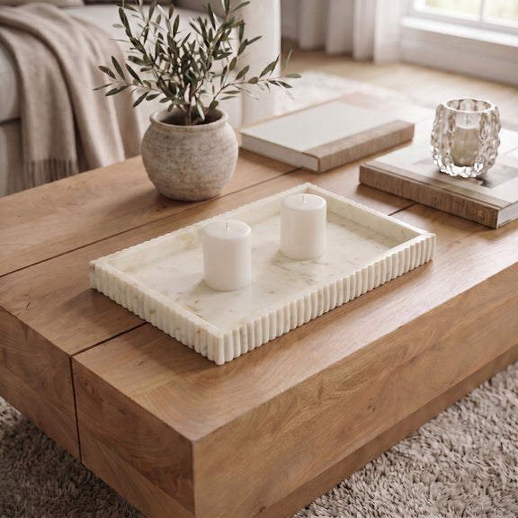 White marble tray with ridged sides holding two white pillar candles