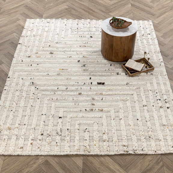 Ivory wool rug with repeating geometric borders and distressed stripe motif