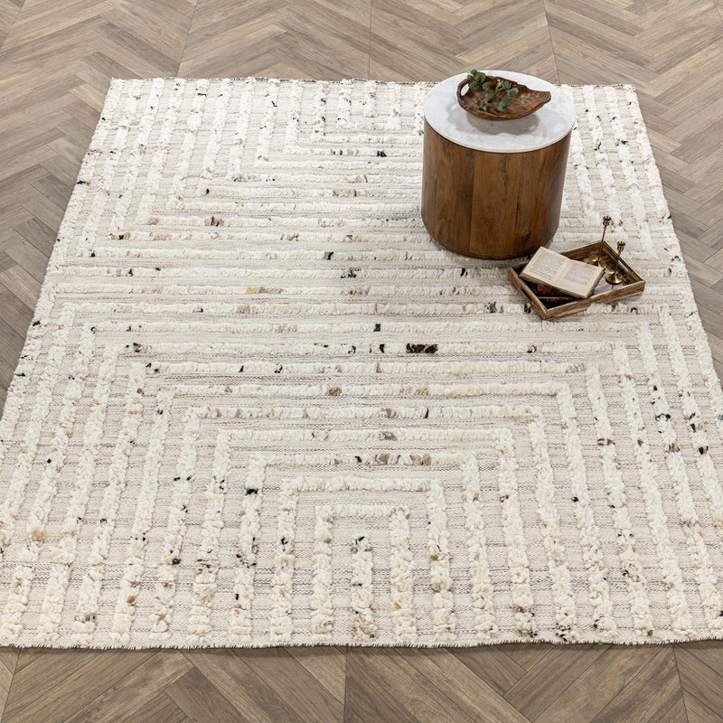 Ivory wool rug with repeating geometric borders and distressed stripe motif