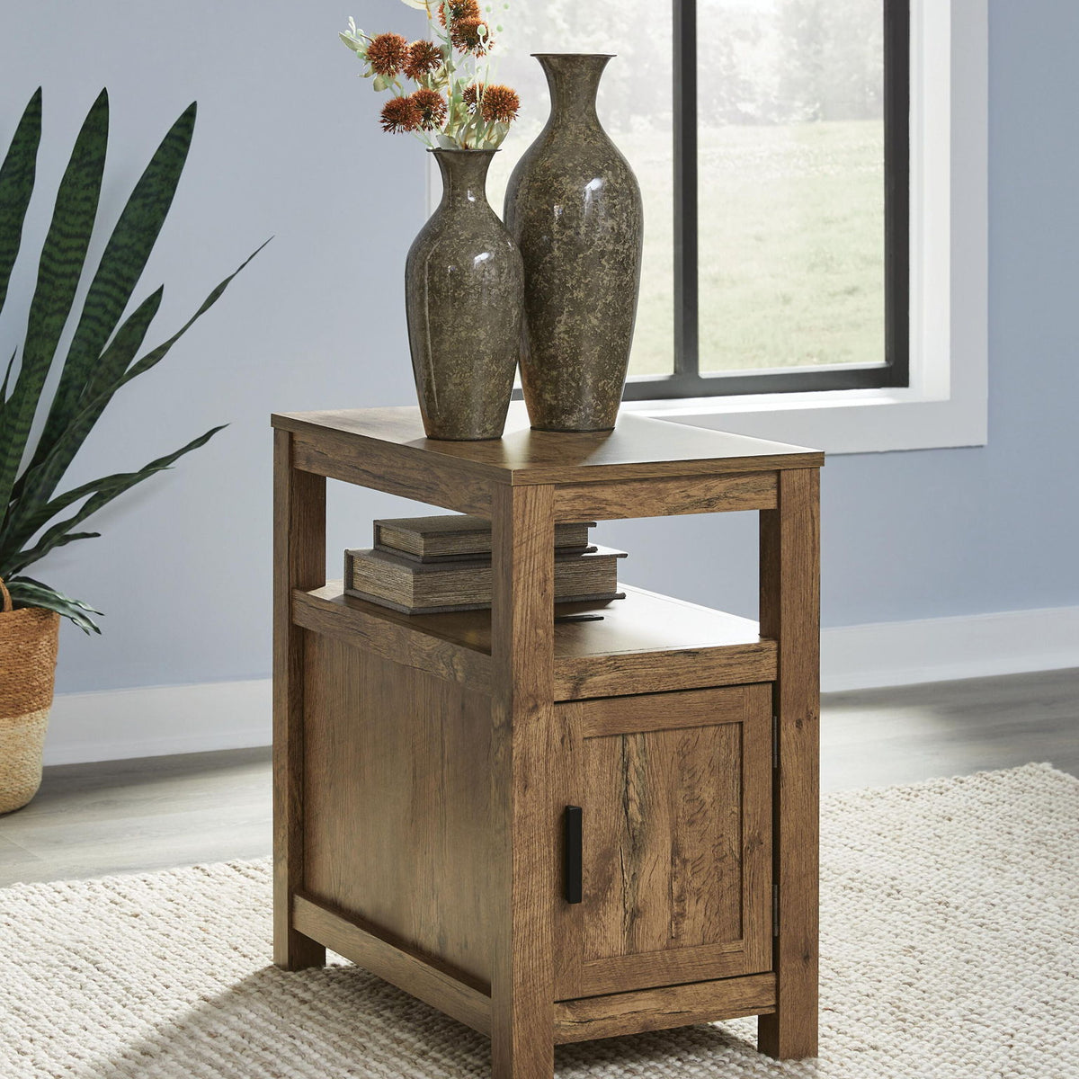 Chair side end table in warm light brown wood with open shelf and cabinet door