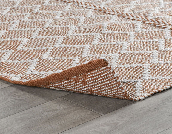 Terracotta indoor/outdoor rug corner with white pattern and woven edge detail