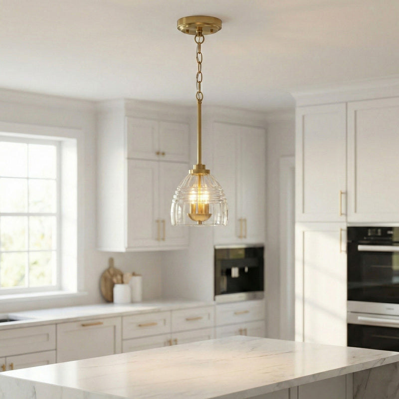 Gold chain pendant light with clear glass globe and three glowing candle-style bulbs